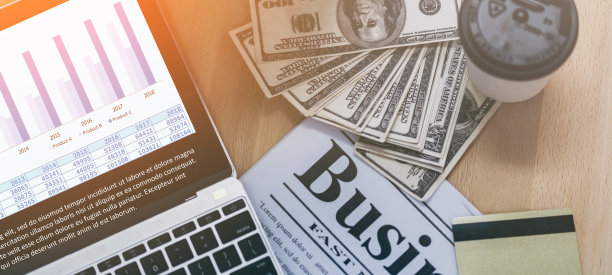 商业理念与报纸、钞票、笔记本电脑和咖啡在办公桌上的概念图片下载