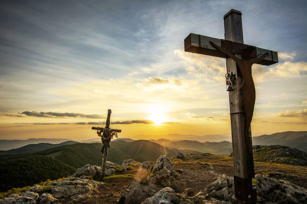 一个唤起宗教十字架在山顶在日落时间与视野的大海图片下载