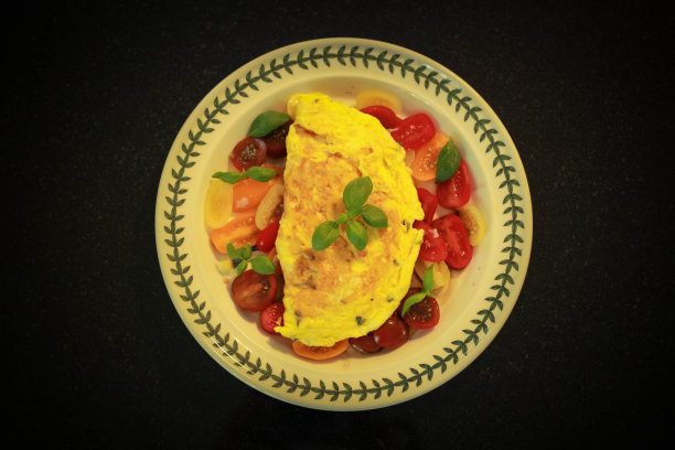 上面有西红柿和罗勒的煎蛋卷。图片下载