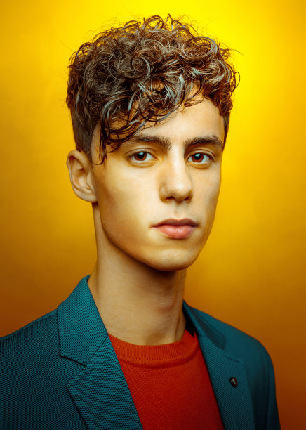 年轻英俊的男子肖像在黄色的背景图片下载