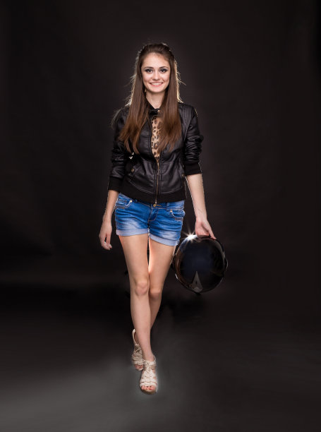 穿着黑色夹克和牛仔短裤的年轻女子。图片下载