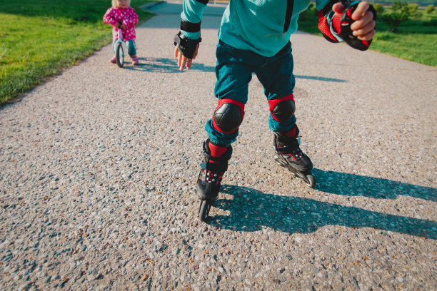 穿着旱冰鞋的孩子和在外面骑跑步车的小女孩图片下载