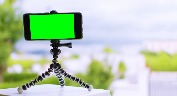 三脚架上的智能手机，上面有绿色屏幕图片下载