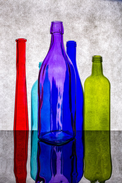 彩色瓶子在反光表面上的静物画图片下载