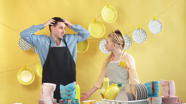 男人和女人在一个孤立的背景和一堆脏盘子图片下载