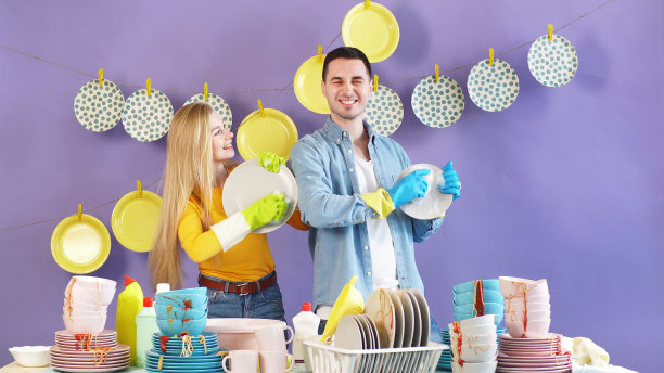 迷人的情侣在好心情下从事家务，洗聚会后的脏盘子图片下载