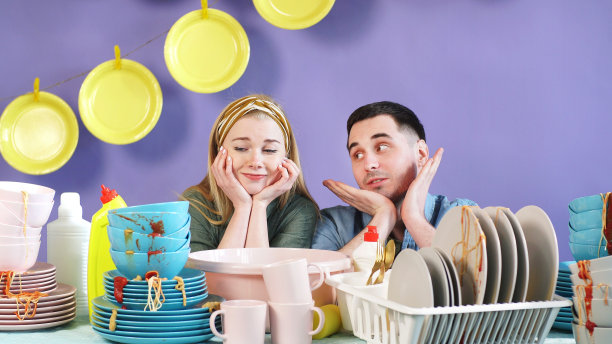 男人和女人在一个孤立的背景和一堆脏盘子图片下载