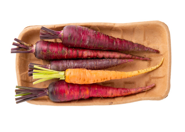 一堆五颜六色的生胡萝卜放在白色的纸盘上。前视图。图片下载