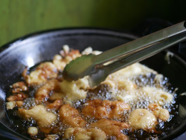 有人在热油锅上煎香蕉。皮桑炒基本上是香蕉裹上面糊，然后在热油中油炸。油炸后，面糊变得酥脆、香甜、柔嫩。图片下载