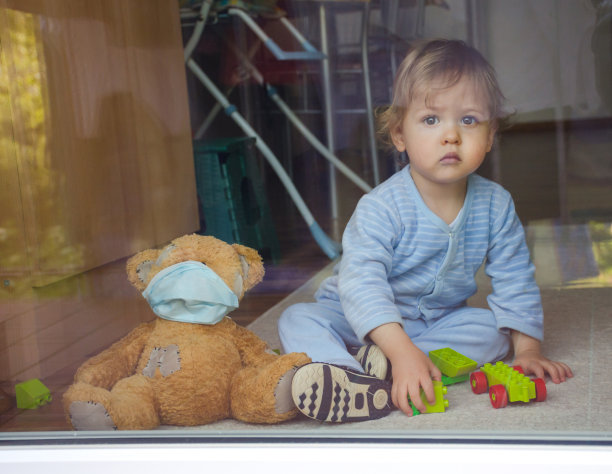 2019冠状病毒病和流感疫情期间，居家隔离的儿童与生病的泰迪熊在窗口玩耍。透过窗户拍摄的照片图片下载