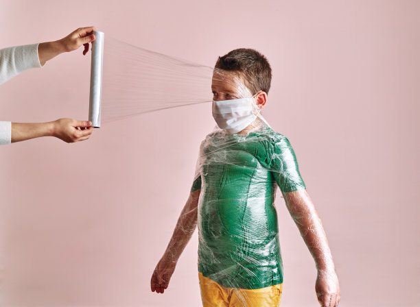 母亲正在给儿子包裹，以预防冠状病毒感染。图片下载