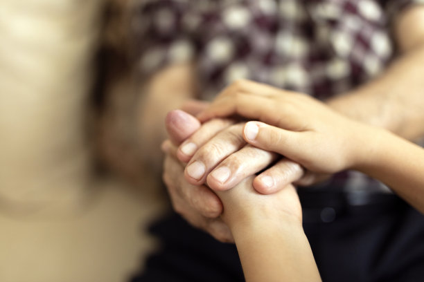 一代又一代的概念。一个孩子的手和一个老人的库存照片图片下载