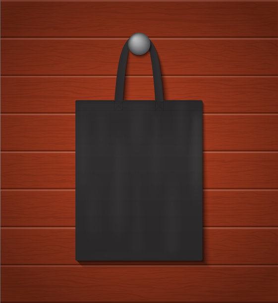 时尚生态手提袋模型挂在木墙上。学校手提袋可重复使用。带把手的黑色帆布袋。棉手提袋购物零售。挂在钉子上做广告的手提包。向量。图片下载