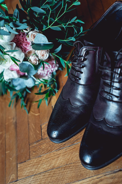 特写的现代男人配件。黑色领结，皮鞋，腰带和婚礼花束在木乡村背景。适合正式的穿着风格图片下载