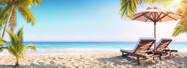 热带海滩上的椅子和带棕榈树的阳伞图片下载