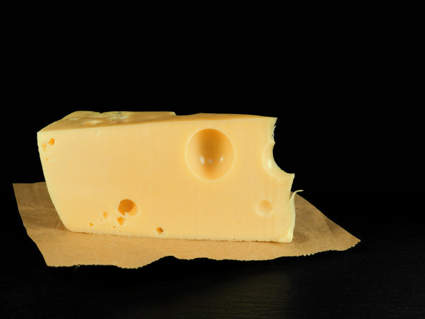 黑色背景上的一块奶酪图片下载