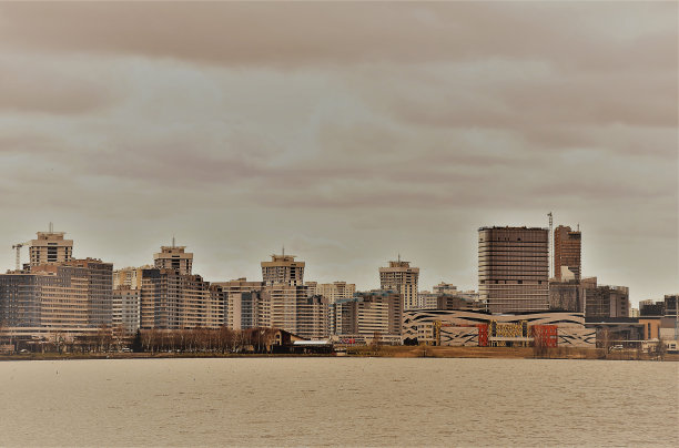 程式化的城市全景在棕色色调，sepio，复古，位于河对岸，高层建筑，平面建筑图片下载