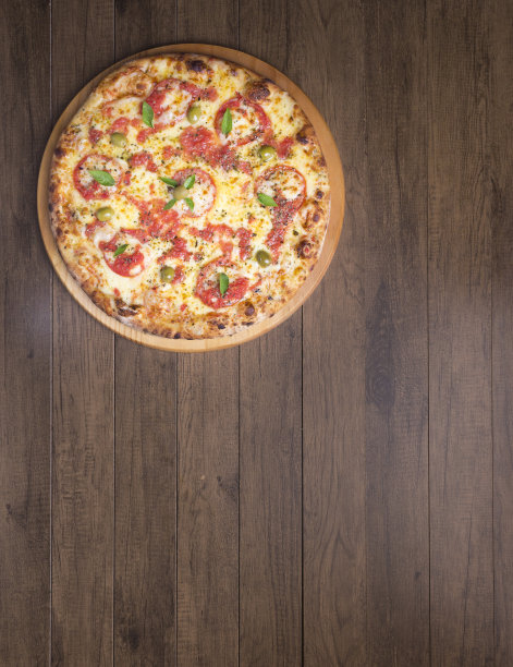 玛格丽特披萨由美味的披萨面团，马苏里拉奶酪，西红柿，马郁兰和绿橄榄制成。放在木板上。Napolitan披萨。精致的美食。美食照片左上角垂直上方。图片下载