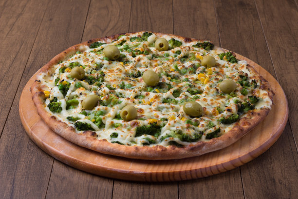 美味的西兰花披萨在木板上。与马苏里拉奶酪、西兰花、玉米、豌豆、橄榄和酱汁一起烘烤。食物在中间的水平照片。图片下载