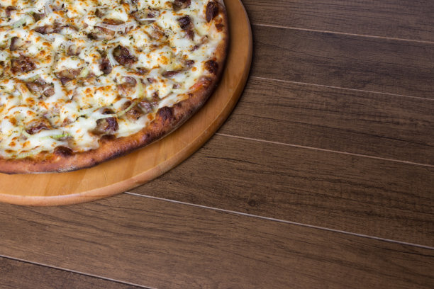 肉披萨放在木板上。由马苏里拉奶酪，picanha肉，洋葱，奶酪，番茄酱制成。菲力牛排,肉。高角度照片与空间写。图片下载