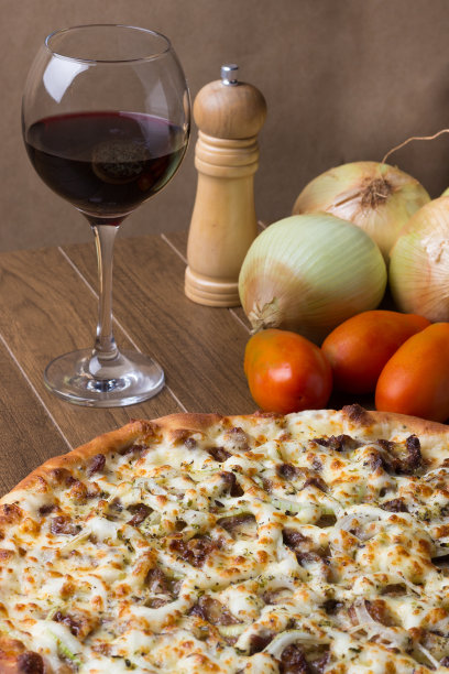 肉披萨放在木板上。由马苏里拉奶酪，picanha肉，洋葱，奶酪，番茄酱制成。菲力牛排，肉，胡椒粉，一杯红酒。垂直的照片。图片下载