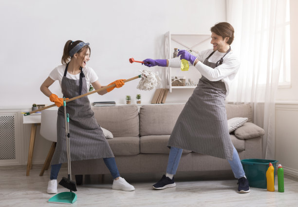 做家务的乐趣。年轻夫妇在家里春季大扫除时在一起嬉戏图片下载