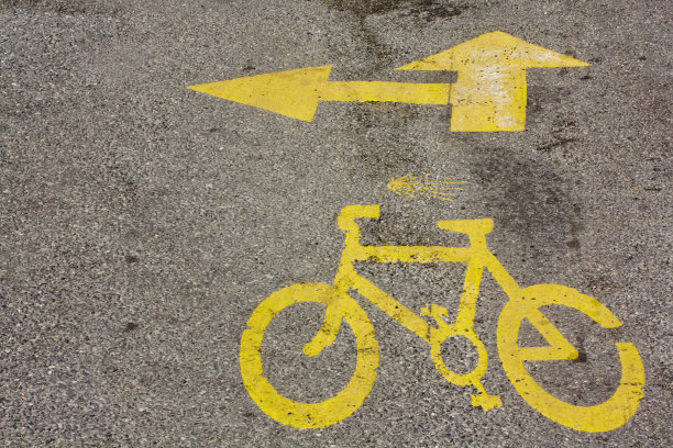 黄色箭头和自行车标志在柏油路在圣地亚哥。图片下载