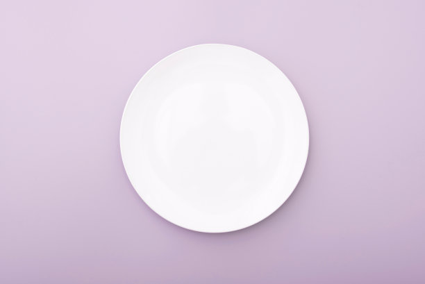 白色陶瓷板在粉红色的桌子上，顶视图白色的盘子。圆形盘子,碗里。图片下载