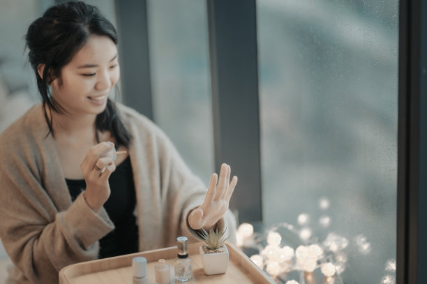 一个亚裔中国女孩在卧室里擦指甲和涂指甲图片下载