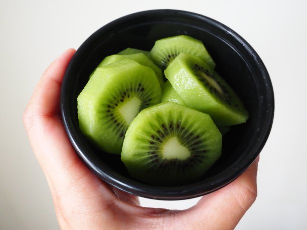 手拿黑碗里的猕猴桃图片下载