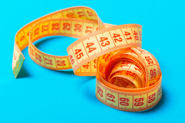 蓝色背景上的螺旋卷尺透视图。近距离的瘦身概念图片下载