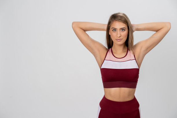 健身女人伸展手臂在时尚的红色运动服库存照片图片下载