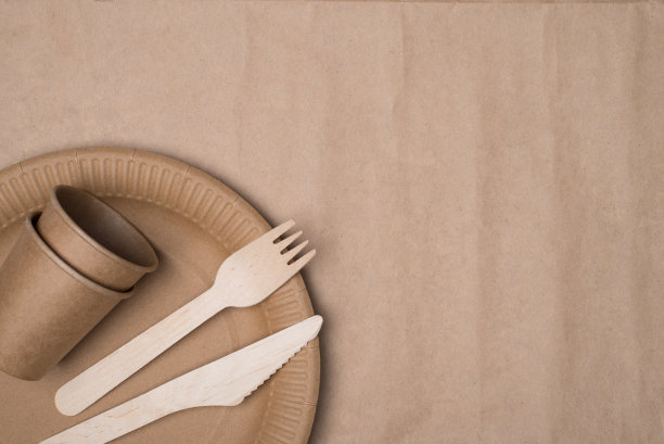 上面的俯瞰照片木制餐具和纸杯和盘子放置在左下角孤立的工艺纸背景表图片下载