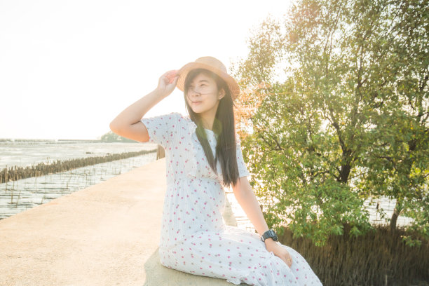 美丽的日落天堂女人放松在太阳夏天的海滩度假户外坐在观看日落在佛罗里达，墨西哥湾的情人关键炮击目的地，美国旅行。亚洲女孩宁静图片下载