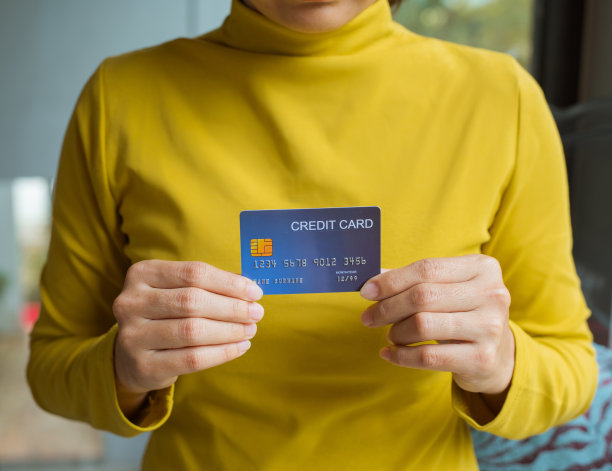 女性手里拿着一张信用卡。网上购物的概念。图片下载