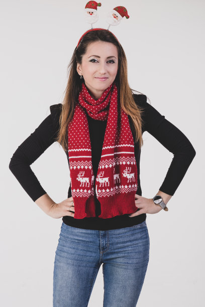 快乐的女人与圣诞头巾和红围巾孤立在一个白色的背景。图片下载