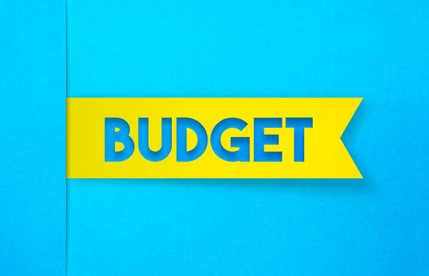 蓝色背景上的黄色标签贴纸。预算的概念。图片下载