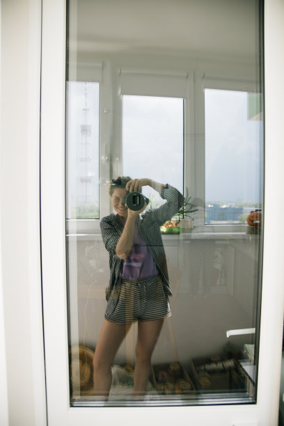 一个女孩在窗前拍自己的照片图片下载