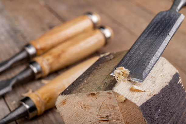 用木匠的凿子凿松木。家庭作坊的小木工工作。明亮的背景。图片下载