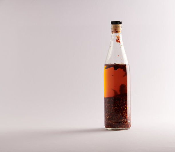 透明的自制辣椒油和干辣椒片，在白色的背景图片下载