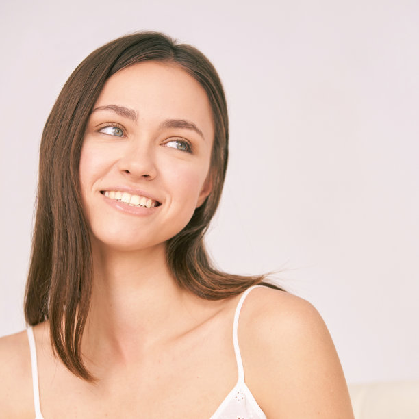 年轻美丽的面部肖像。抗粉刺美容治疗。露出牙齿微笑。成年女性在美容院做手术图片下载