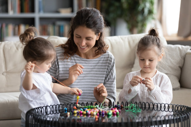 快乐的年轻妈妈和小女儿一起做手镯图片下载