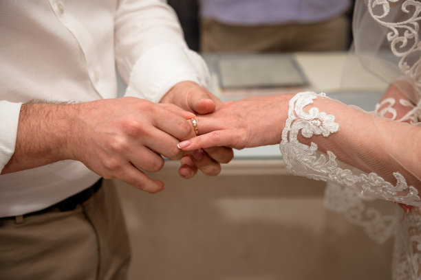 新婚夫妇的手在婚礼上佩戴结婚戒指。图片下载