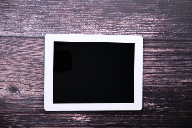 俯视图的数字平板电脑与屏幕上的木制书桌图片下载