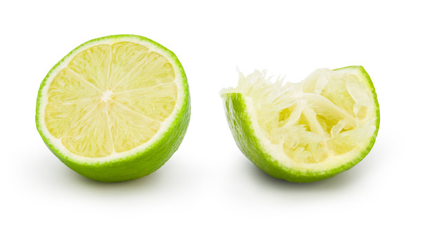 新鲜的酸橙切成两半，在白色背景上投下阴影。商业形象的柑桔水果孤立与修剪路径。图片下载