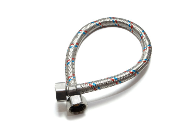 用于供应热水器的白色背景的电缆金属软管。特写镜头。孤立在白色背景上。图片下载