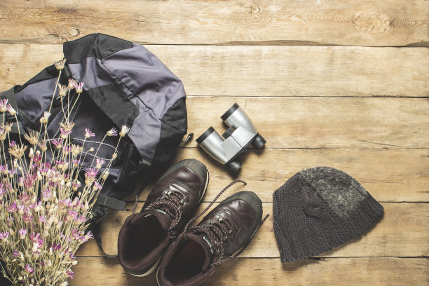 徒步靴，双筒望远镜，木制背景上的徒步配件。徒步、旅游、露营、登山、森林的概念。横幅。平躺，俯视图图片下载