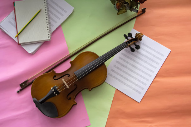 把小提琴和琴弓放在五彩缤纷的背景下，准备练习图片下载