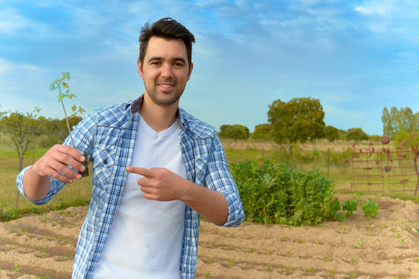 一个年轻人在一个有机花园里种植蔬菜和水果图片下载