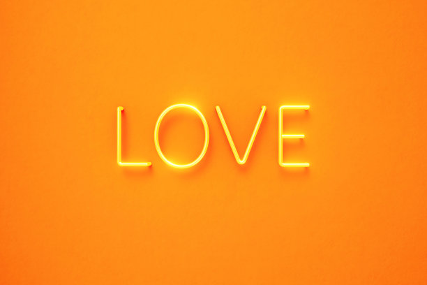 黄色霓虹灯在黄色背景上写的爱的文字图片下载